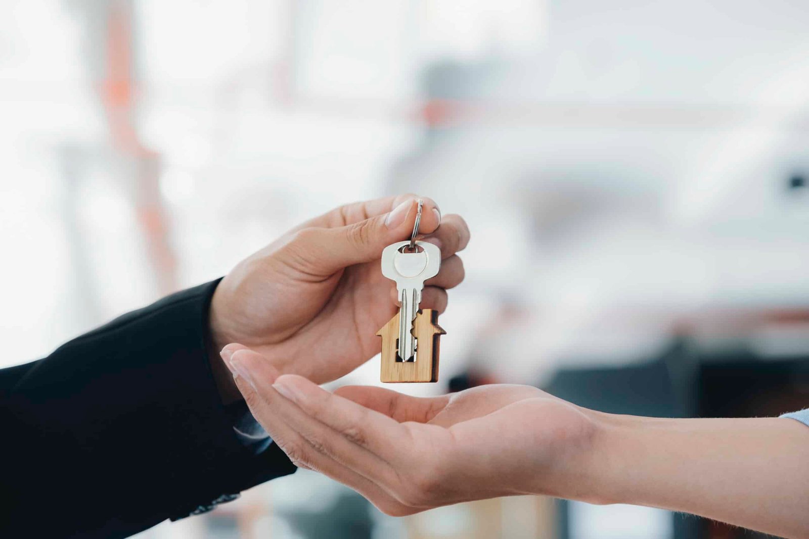real estate agent holding key with house shaped keychain.
